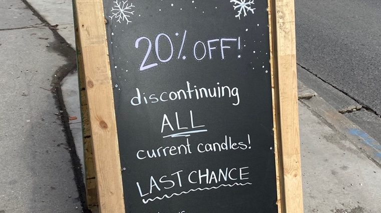 Sign outside of candle store that reads "20% off! Discontinuing ALL current candles. Last chance."