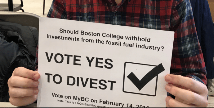 Close up of the "VOTE YES YO DIVEST" sign held by Kyle Rosenthal