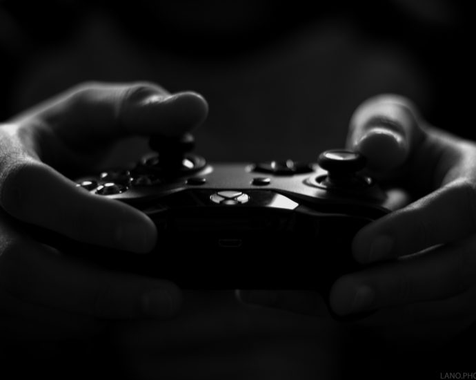 Grayscale image of hands holding X-box controller
