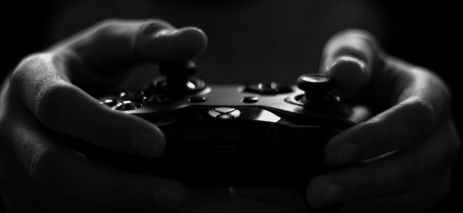 Grayscale image of hands holding X-box controller