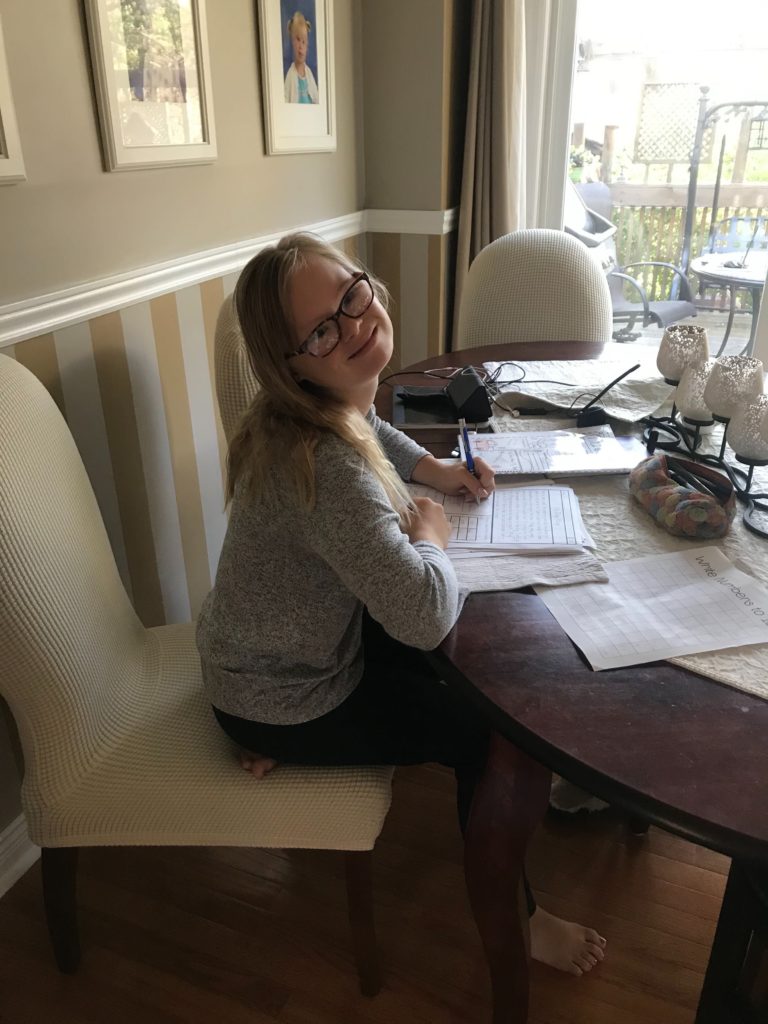 14 year-old girl with down syndrome doing homework at home