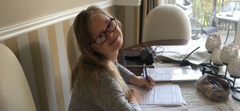 14 year-old girl with down syndrome doing homework at home