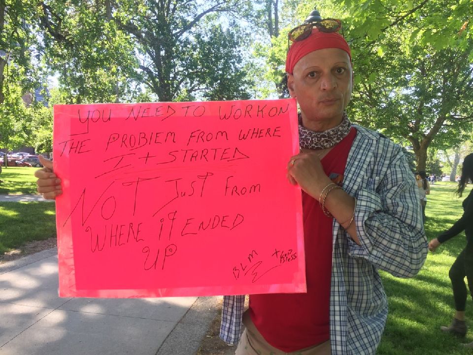 Katu Azzya at the Black Lives Matter London protest holding a sign that says: "You need to work on the problem from where it started not just from where it ended up."