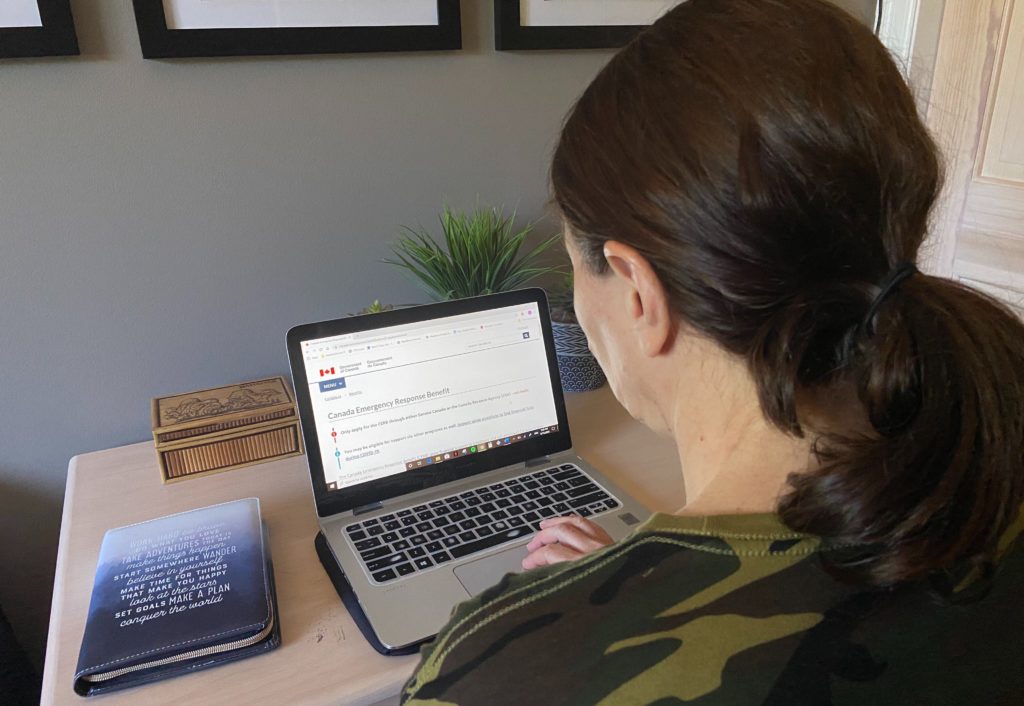 Woman looking at CERB application online after Trudeau has announced extension