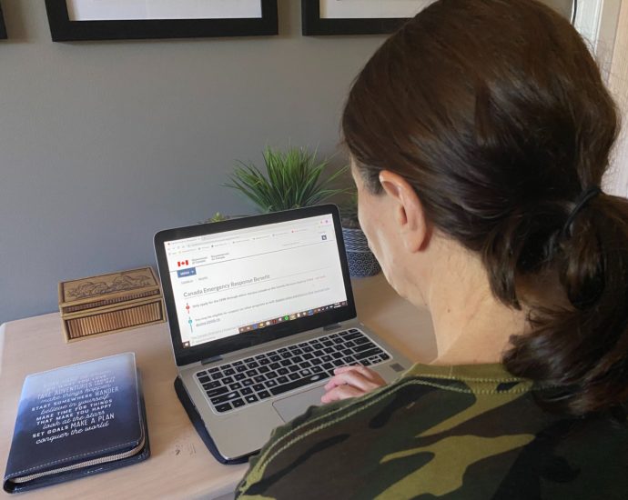 Woman looking at CERB application online after Trudeau has announced extension
