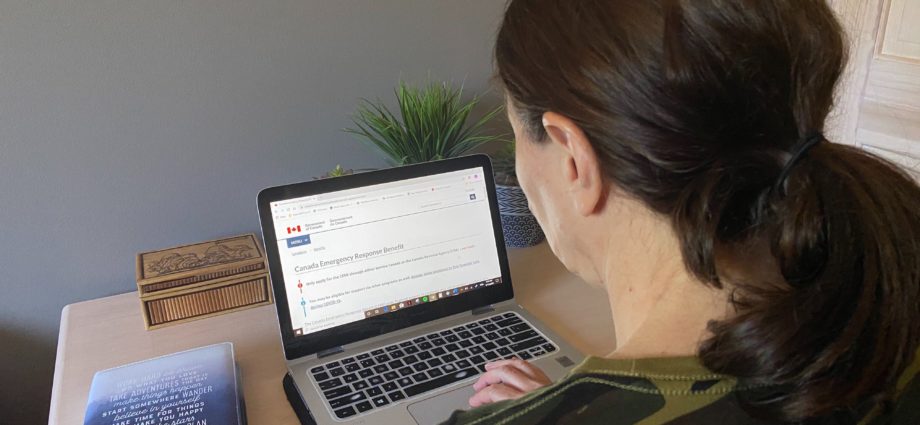 Woman looking at CERB application online after Trudeau has announced extension