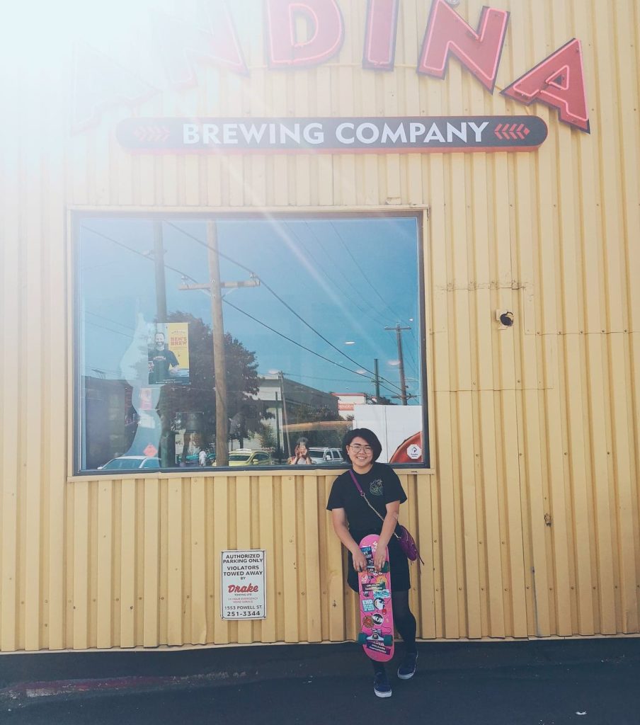 A picture of Eva Zhu standing with her skateboard