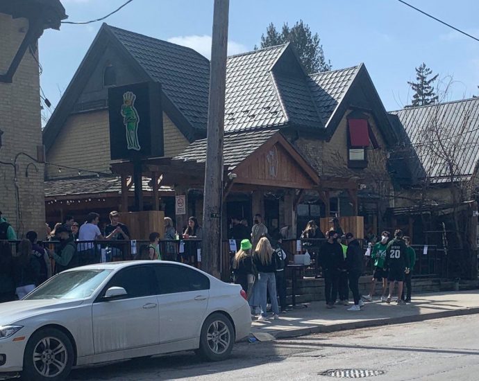 People line up outside bars on Richmond Row in London, Ont.